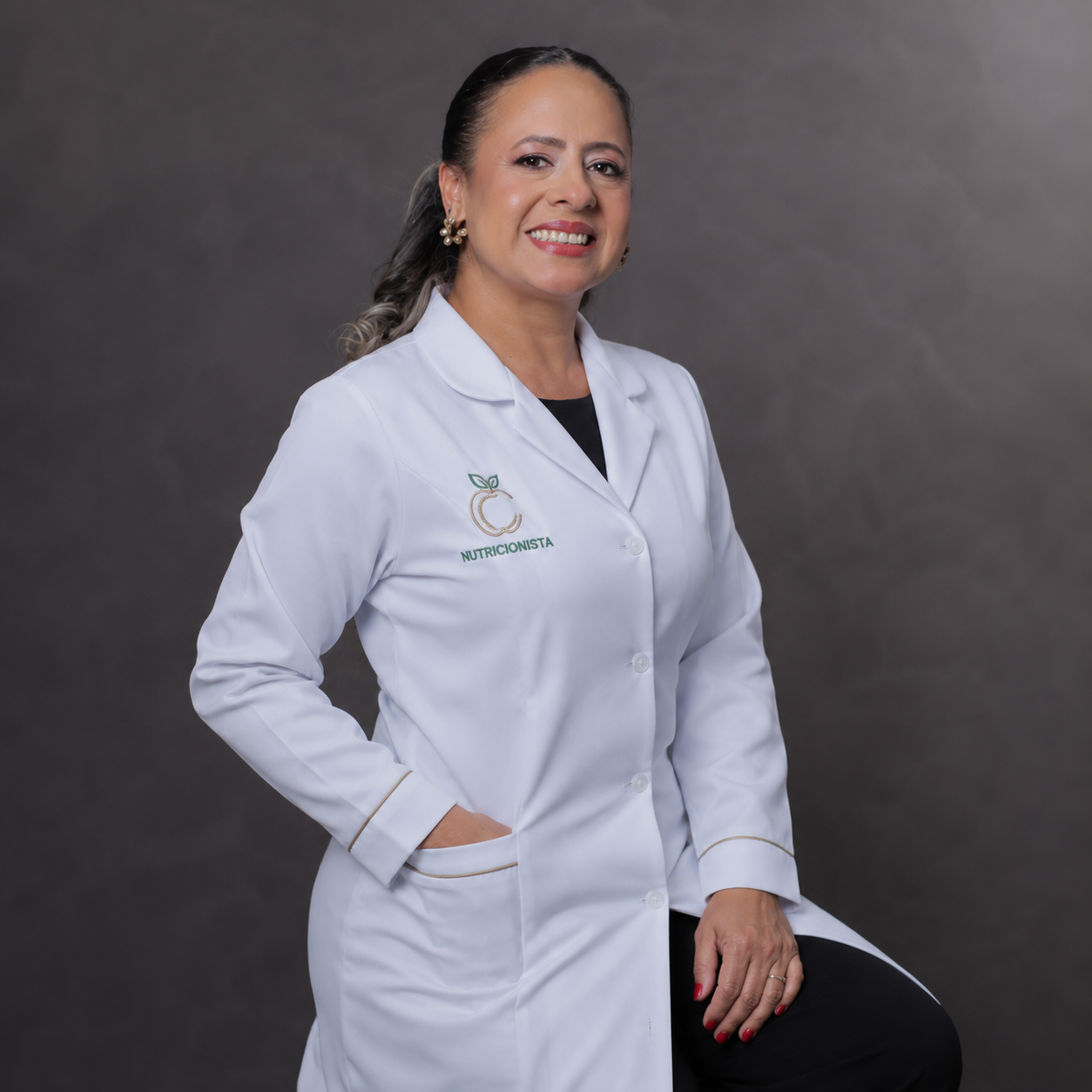 Tassiane, nutricionista, sorrindo com jaleco branco